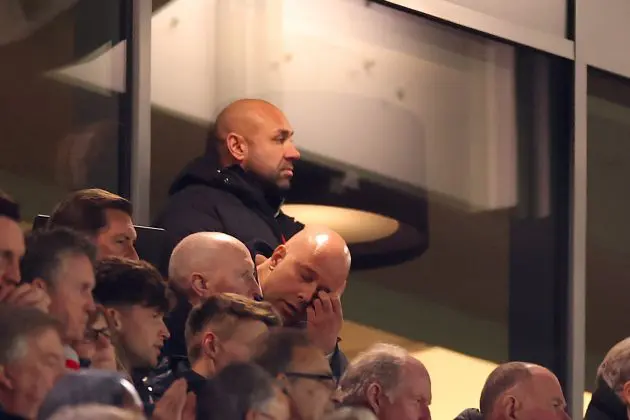 Arne Slot touches his eye in the stands at Anfield.