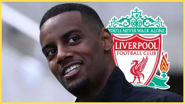 Alexander Isak smiles in front of Liverpool club crest.
