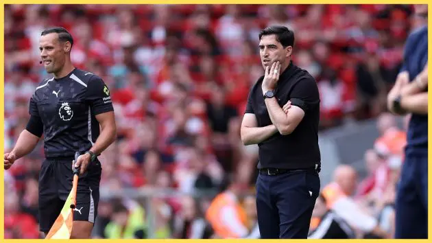 Liverpool manager Andoni Iraola looks concerned while watching his team from the touchline.