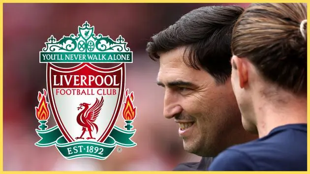 Andoni Iraola smiles looking at the Liverpool club crest.