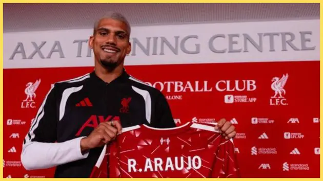 New Liverpool signing Ronald Araujo holds up a LFC shirt.