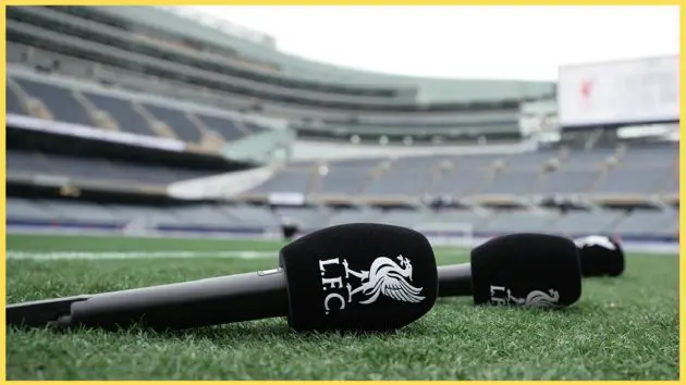 An LFC-embroidered microphone rests on the touchline